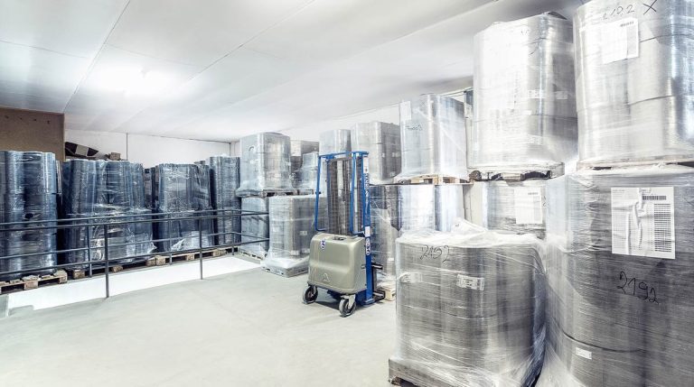 Modernes Lager mit foliengeschützten Materialrollen auf Paletten – Lagerbestände für kurze Lieferzeiten